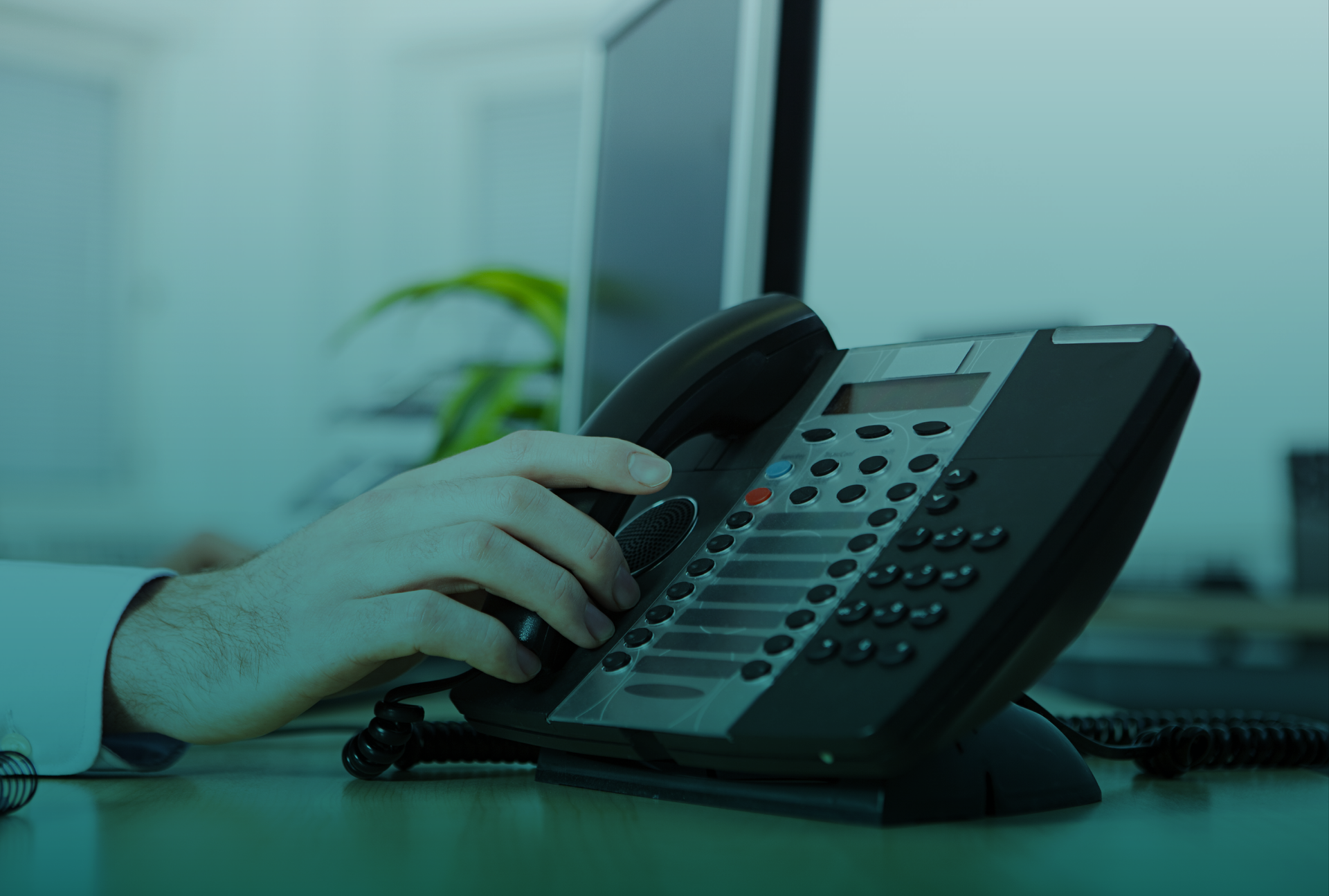 Uma pessoa está usando um telefone em uma mesa.