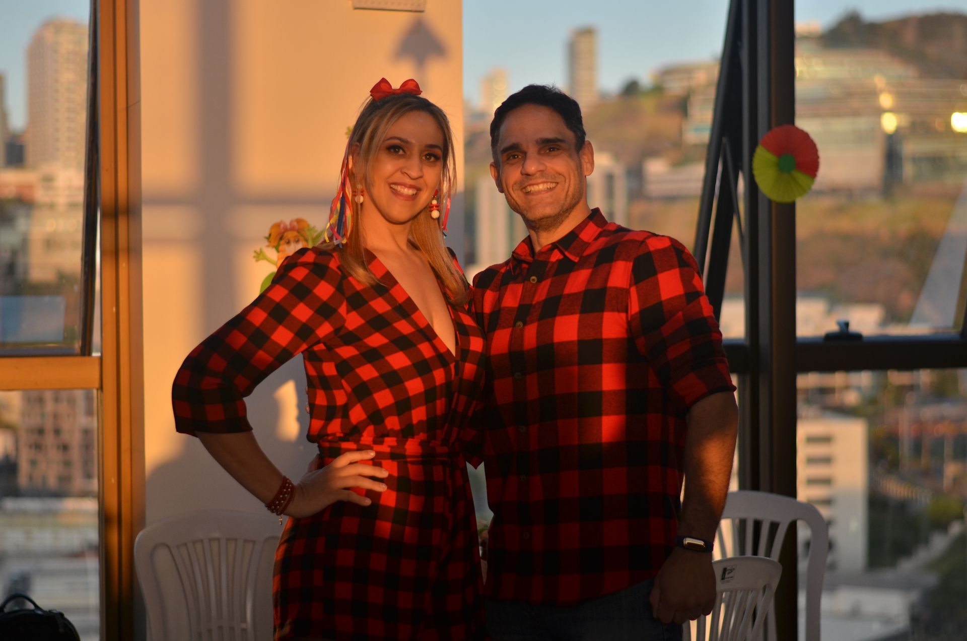 Um homem e uma mulher estão parados um ao lado do outro em frente a uma janela.