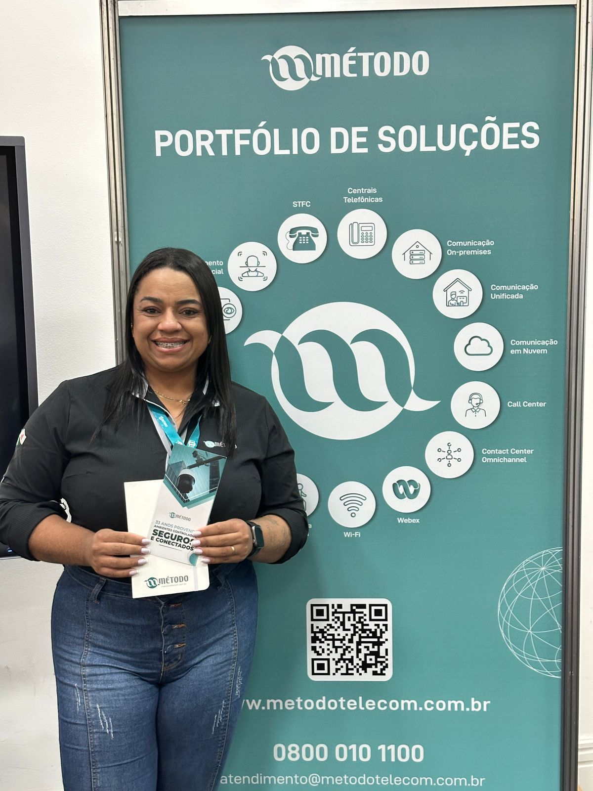 Uma mulher está parada em frente a uma placa que diz portfólio de soluções.