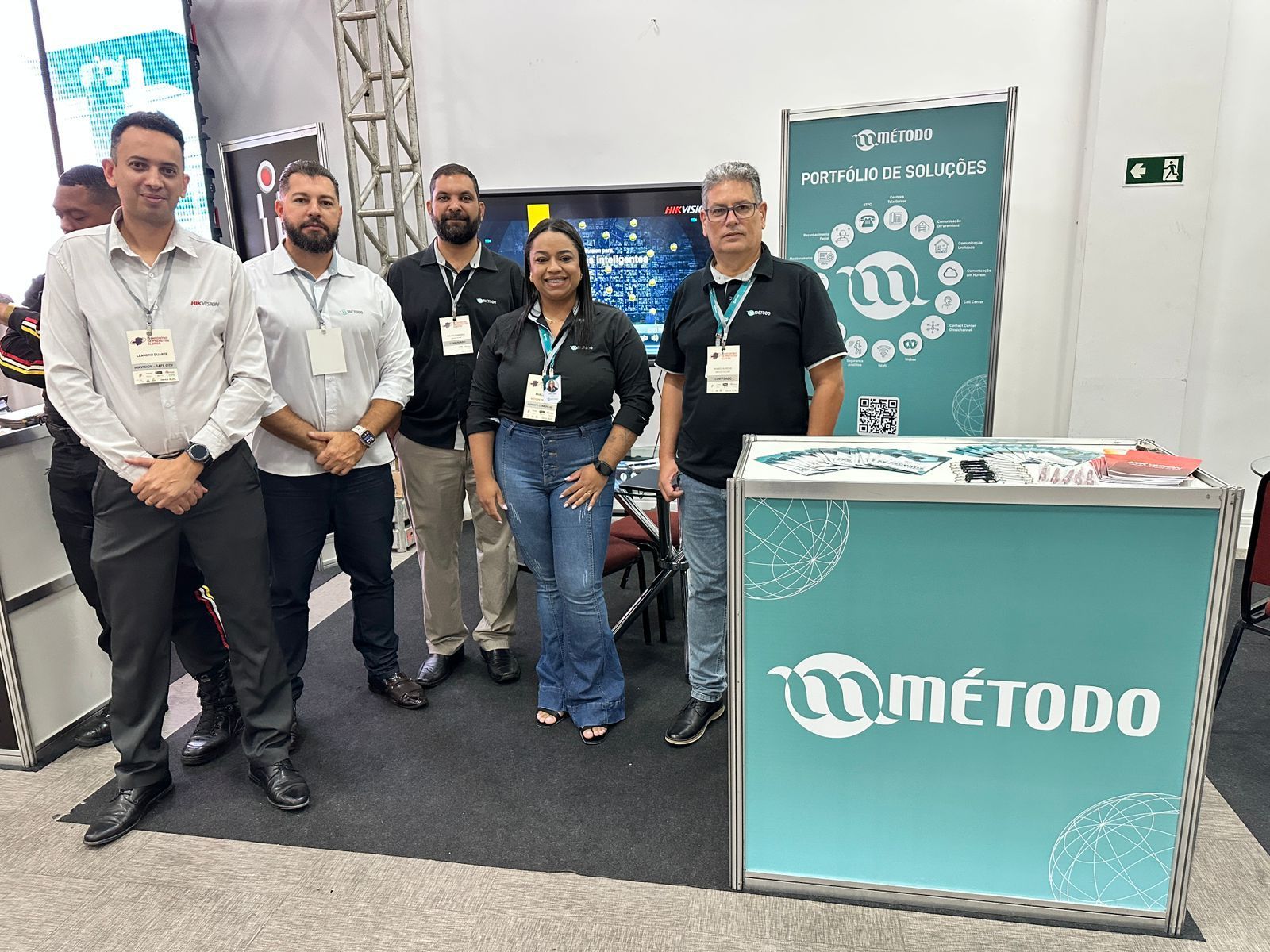 Um grupo de pessoas está posando para uma foto em frente a uma cabine.