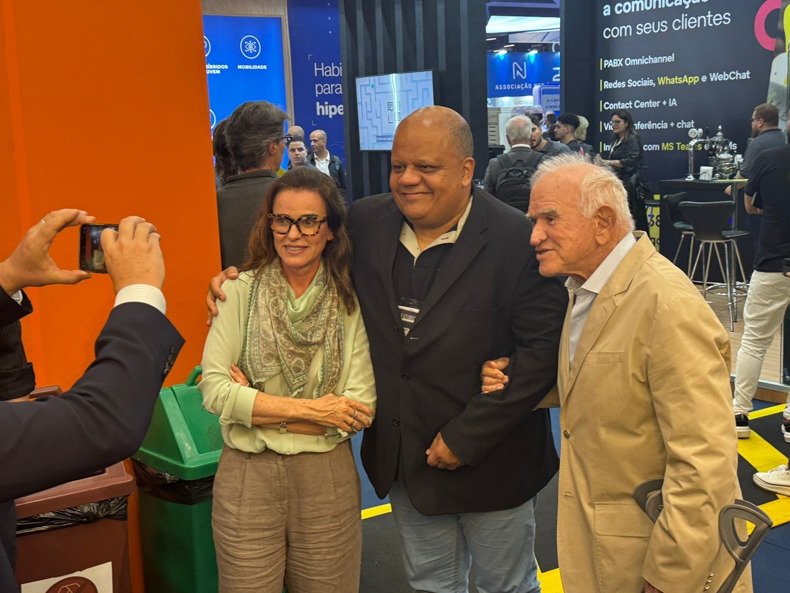 Um homem está tirando uma foto de dois homens e uma mulher.