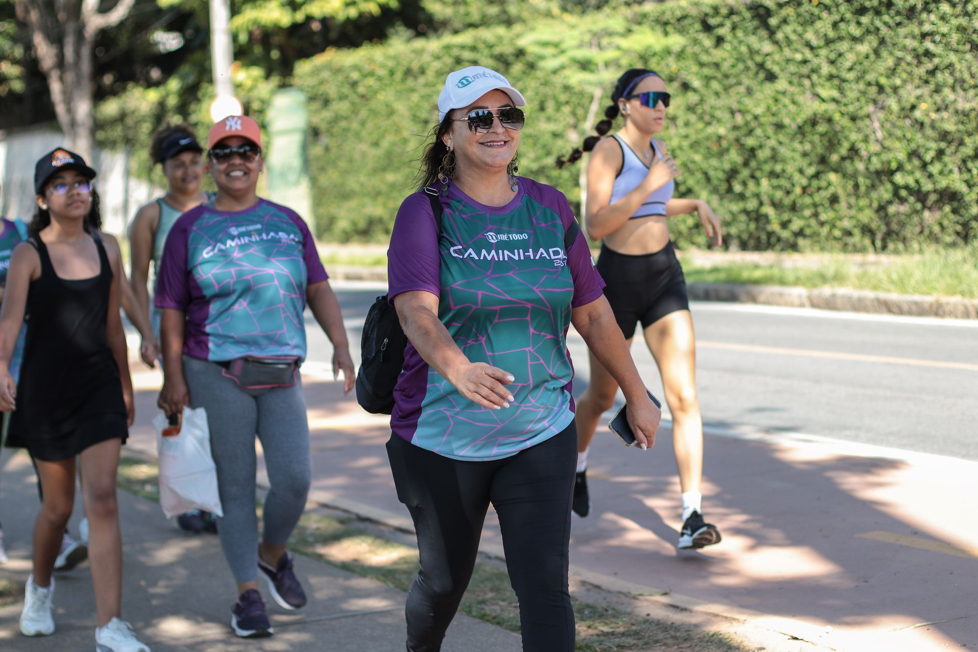 Um grupo de mulheres está caminhando pela calçada.