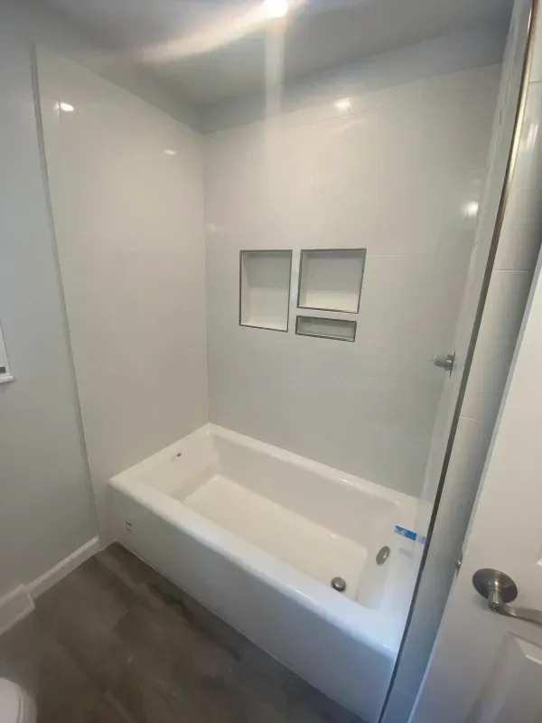 A bathroom with a bathtub and shower stall.