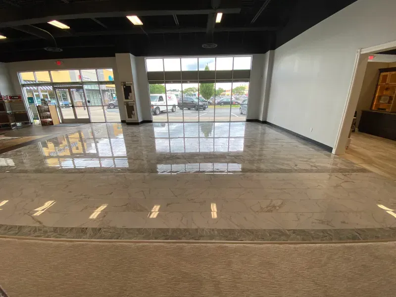 A large room with a lot of windows and a marble floor.