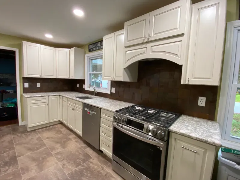 A kitchen with white cabinets and stainless steel appliances.