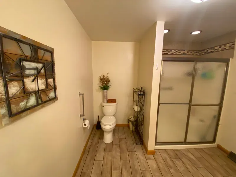 A bathroom with a toilet , sink , and shower.
