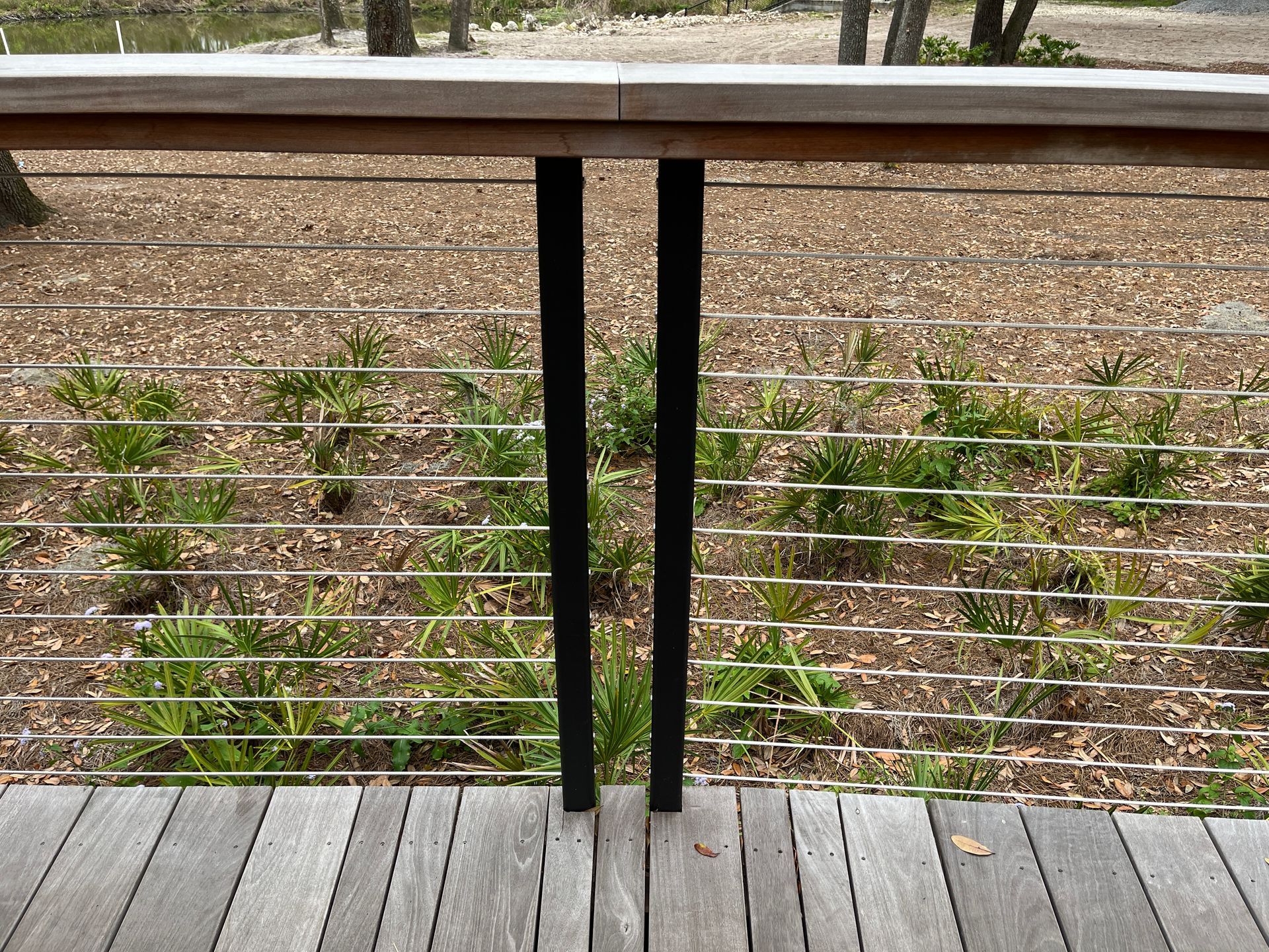 wooden deck with cable railing and wooden topper above posts