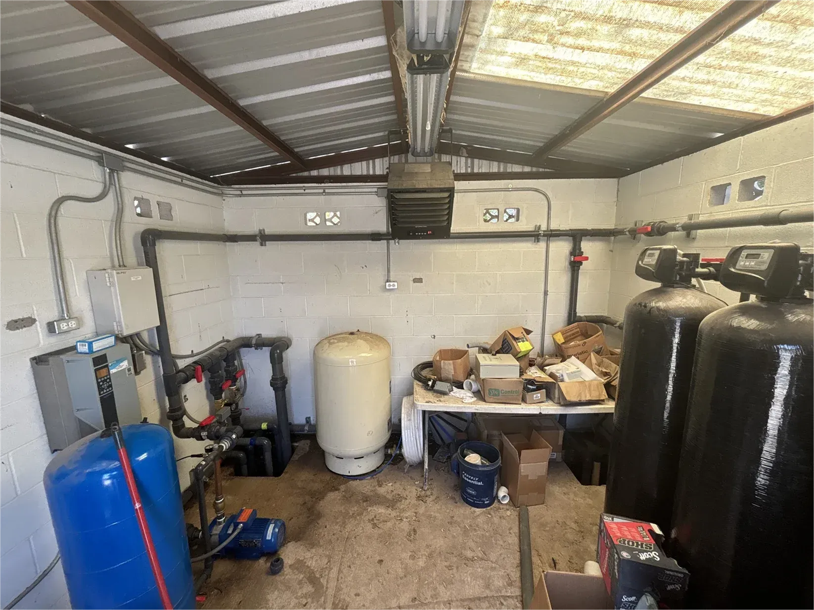 A room with a lot of water tanks and pipes in it.
