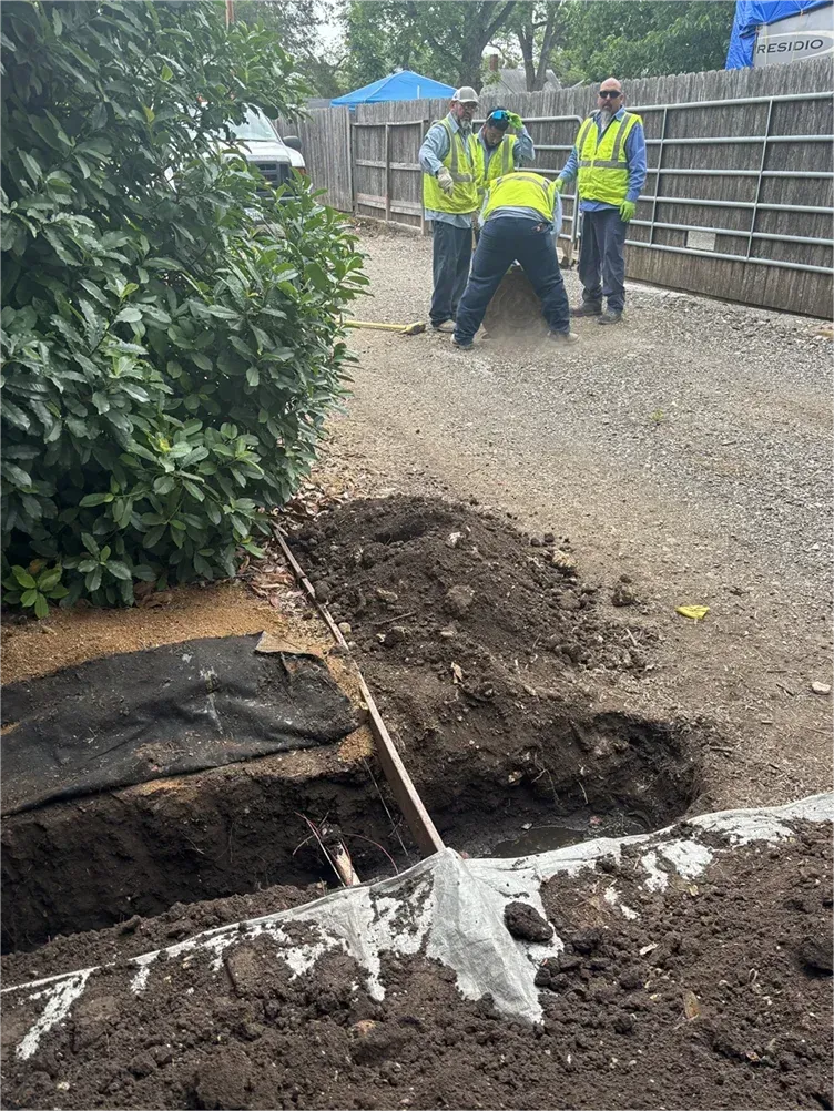 A group of construction workers are digging a hole in the ground.