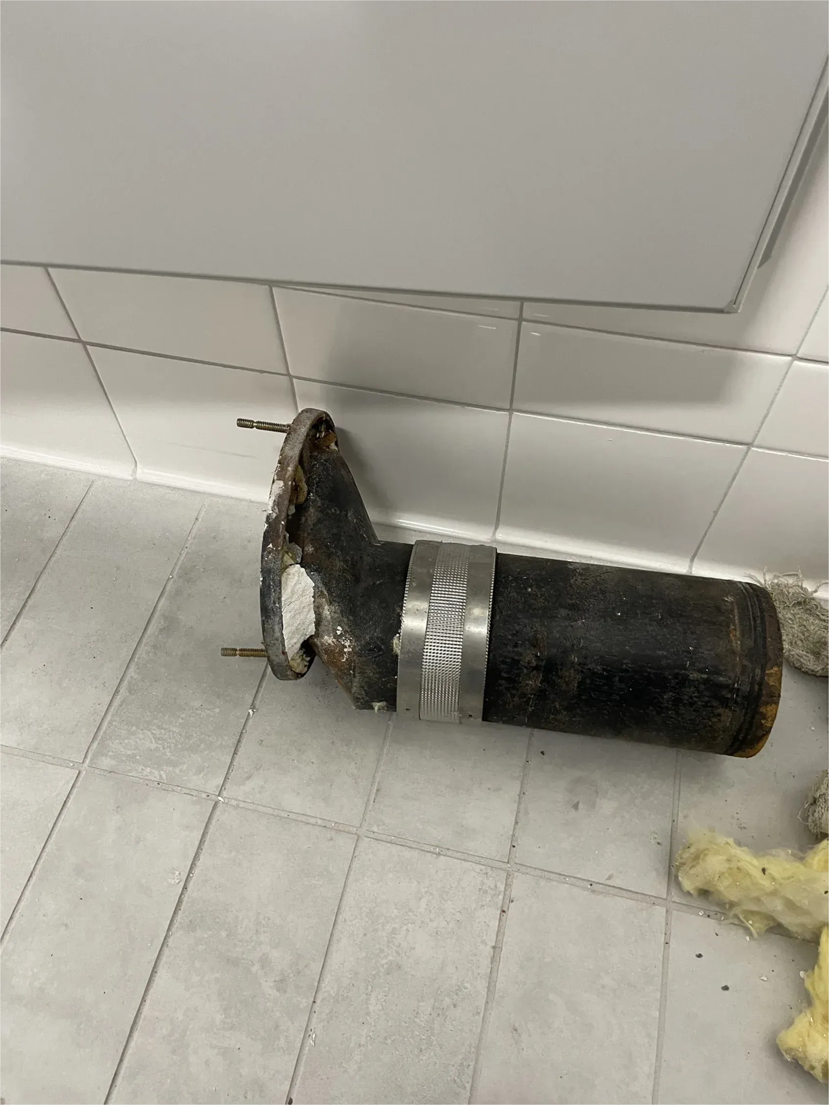 A pipe is taped to the wall in a bathroom.