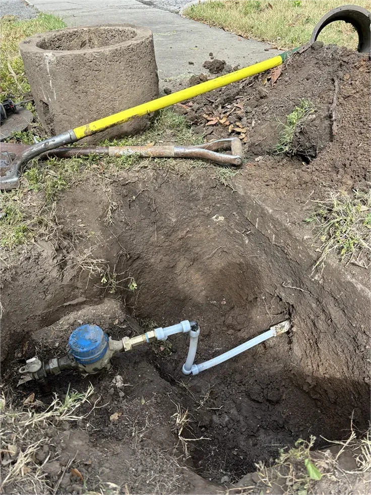 A water meter is being installed in a hole in the ground.