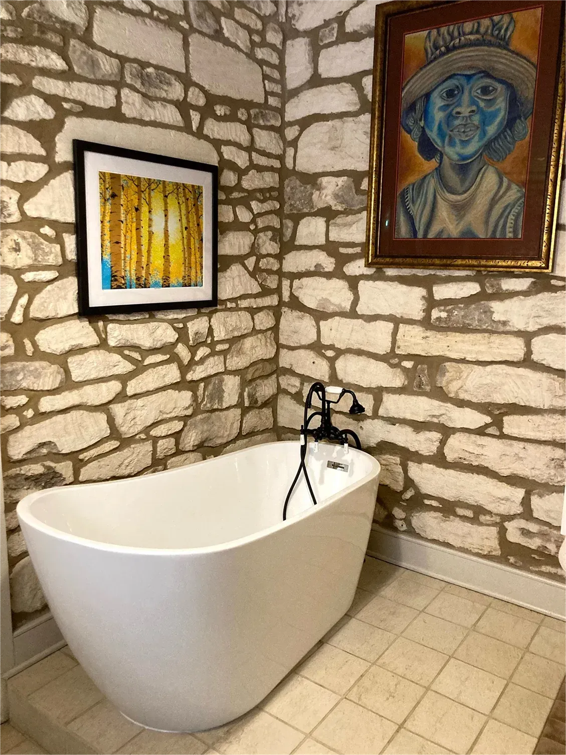 A bathroom with a bathtub and a painting on the wall.