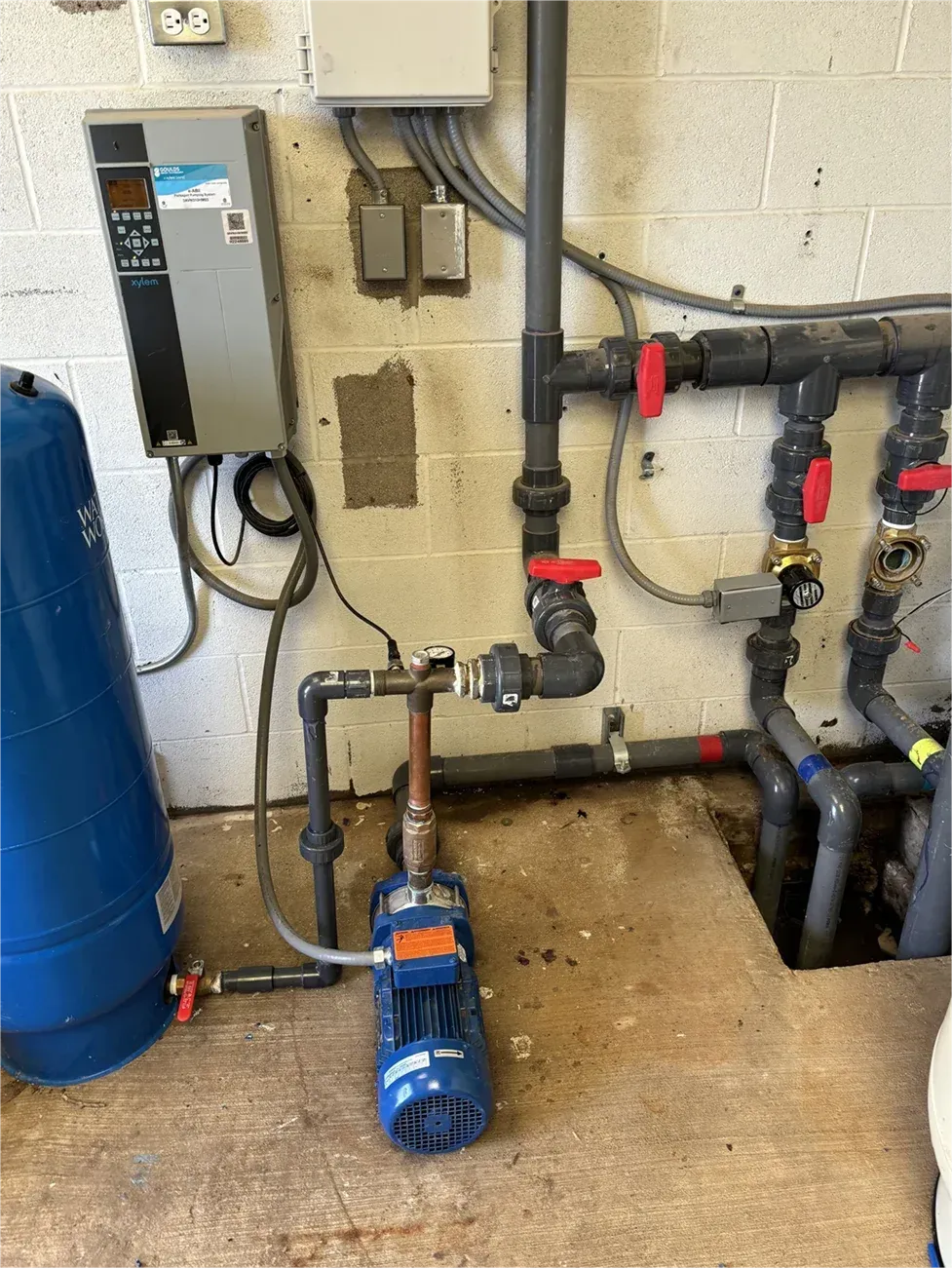 A room with a lot of pipes and a pump.