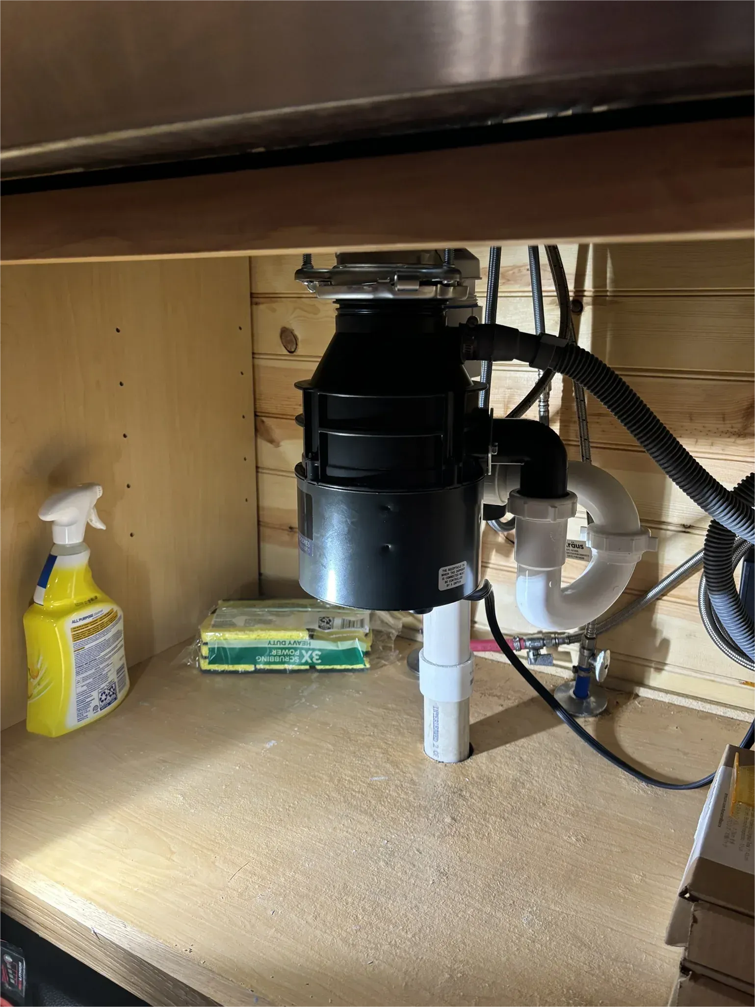 A garbage disposal is sitting under a sink in a kitchen.