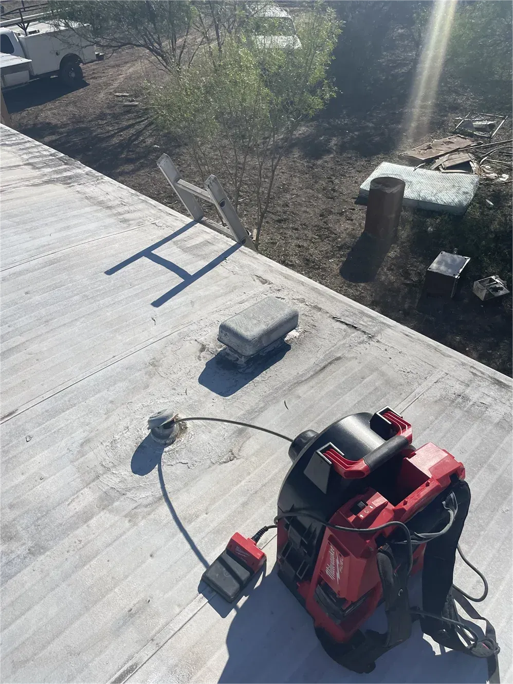 A red milwaukee tool is sitting on the roof of a building.