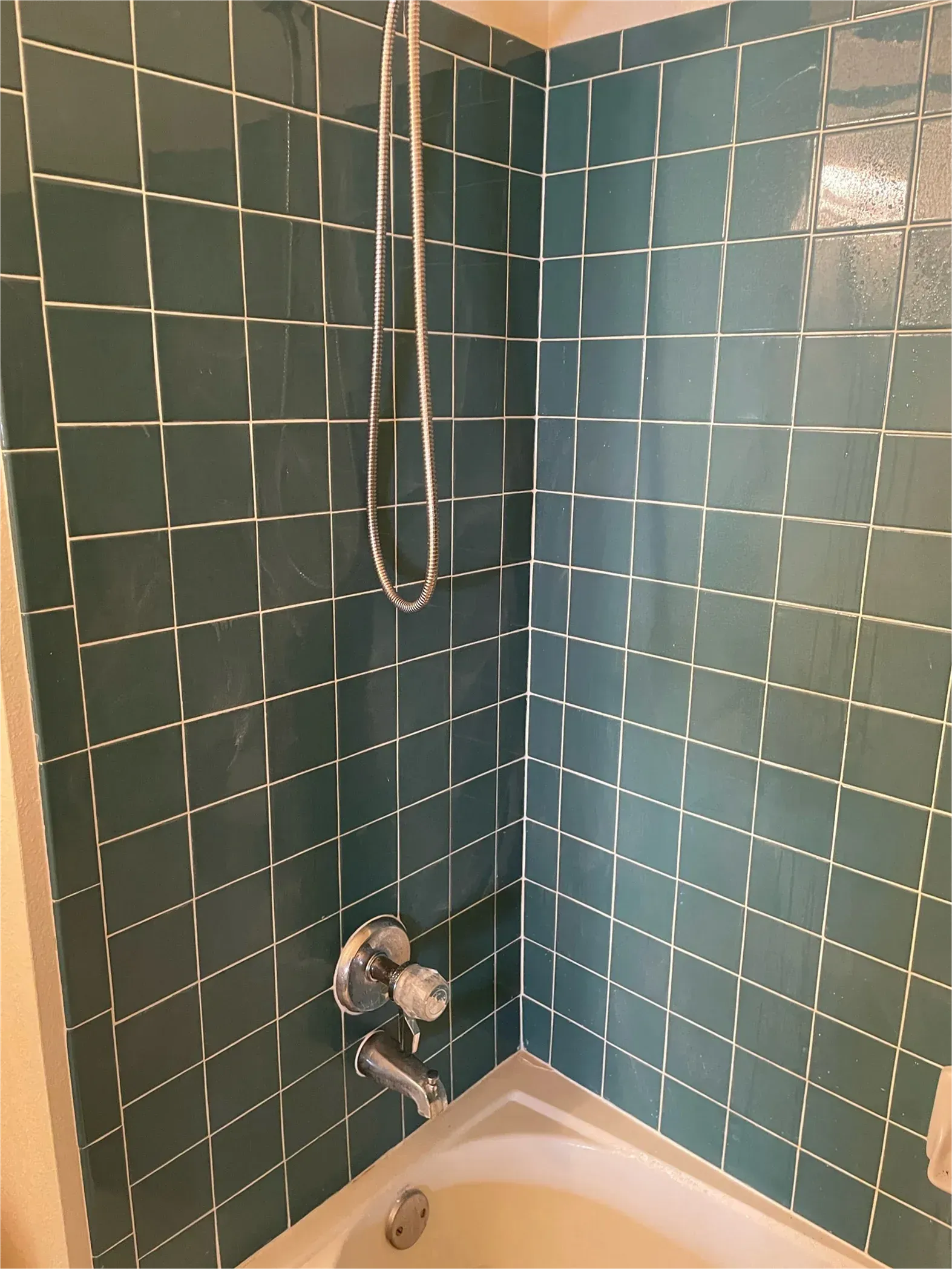 A bathroom with blue tiles and a bathtub