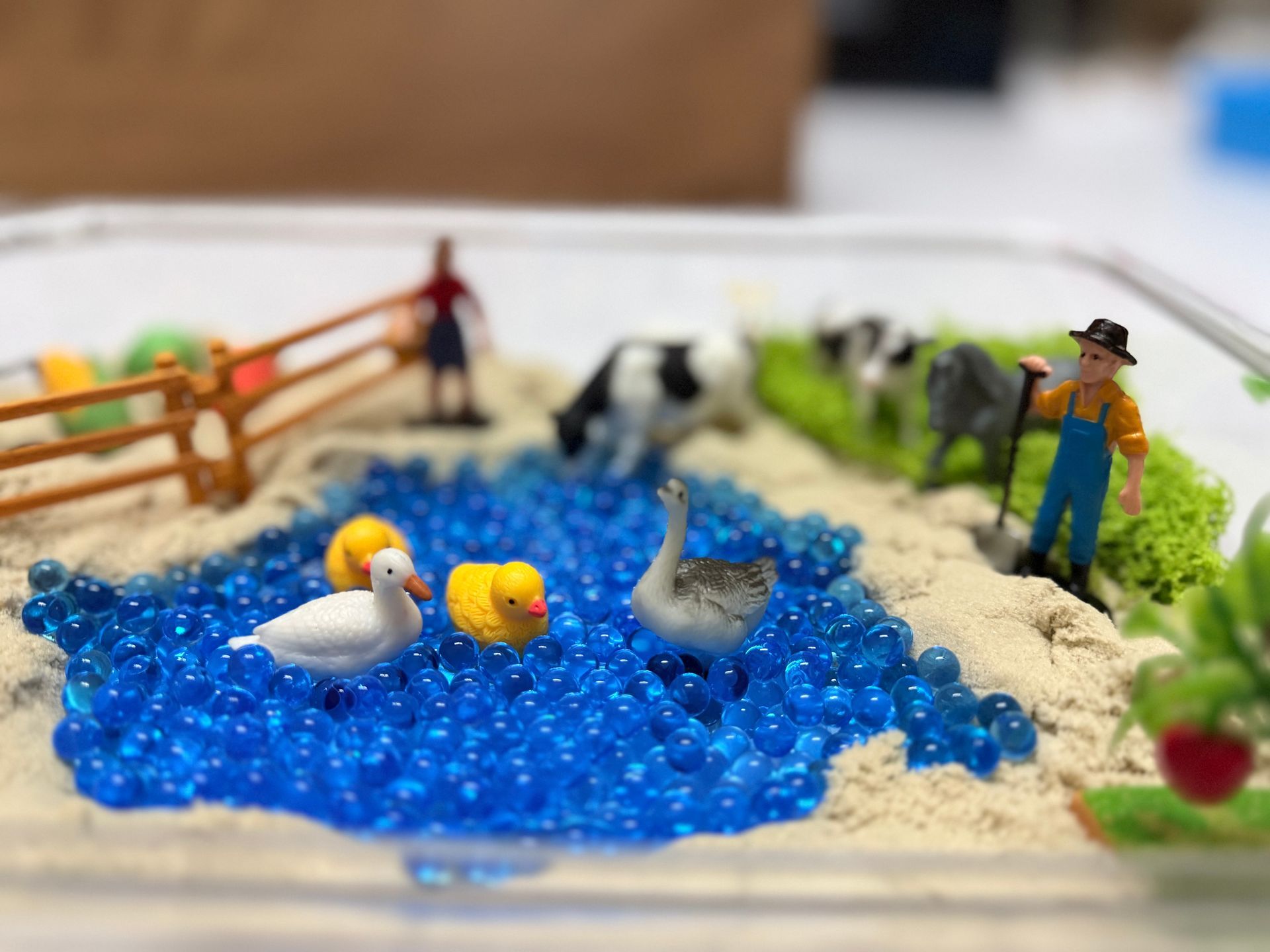 Farm sensory play setup with blue water beads, ducks and animals for kids learning
