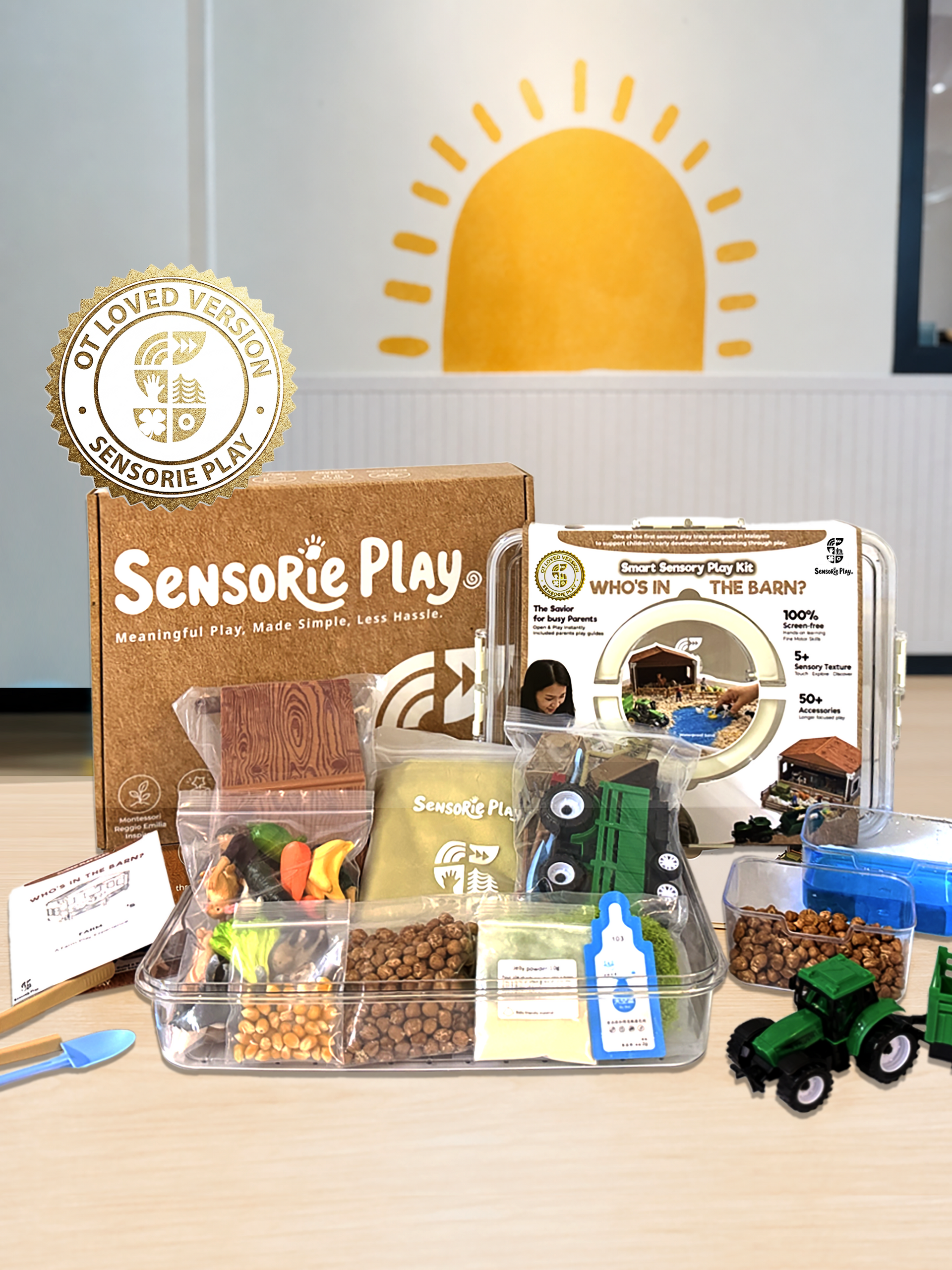 Sensorie Play sensory kit with clear tray, small tools, toy tractor, and packaging on a table