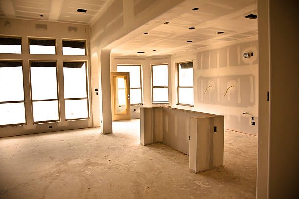 An empty room with a lot of windows and drywall