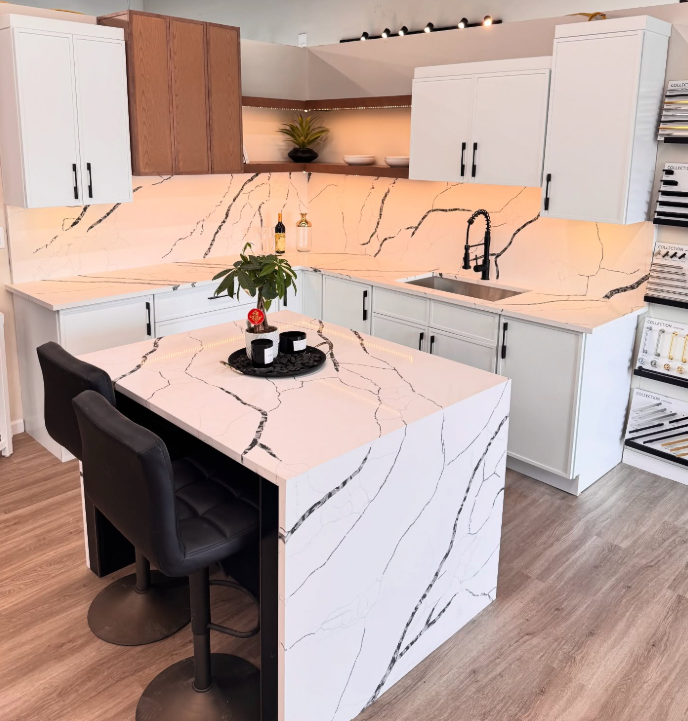 Modern kitchen with white marble-look countertops, white cabinets, wood accents, and a center island with a barstool