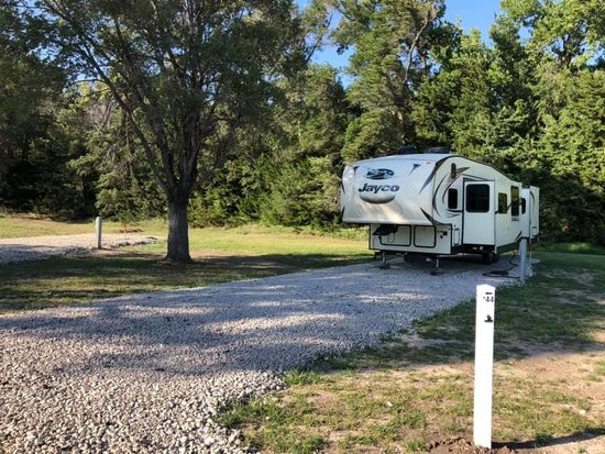 Camper parked on gravel back in at Creek Side Resort in Hays, KS