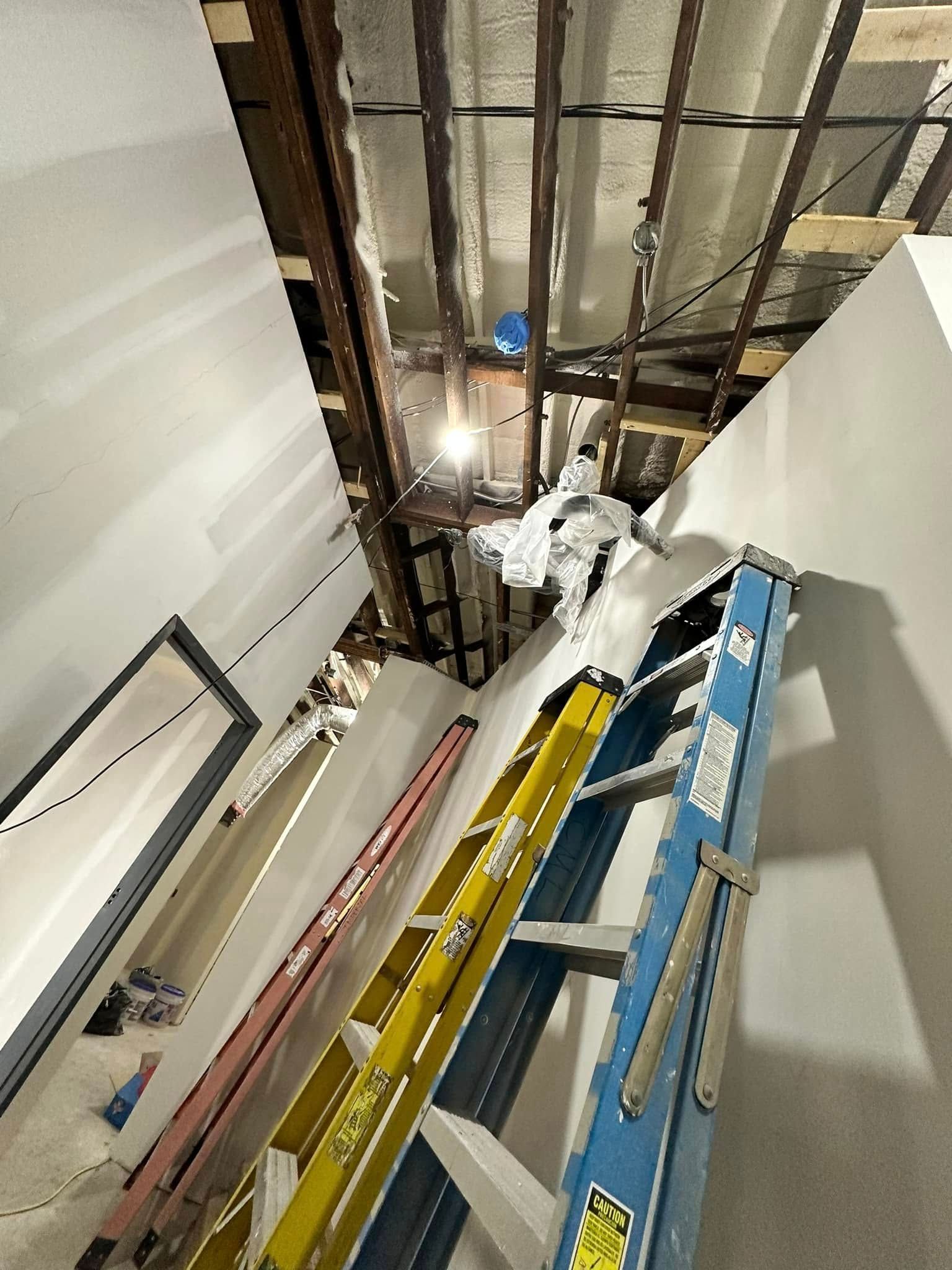 A bunch of ladders are stacked on top of each other in a room.