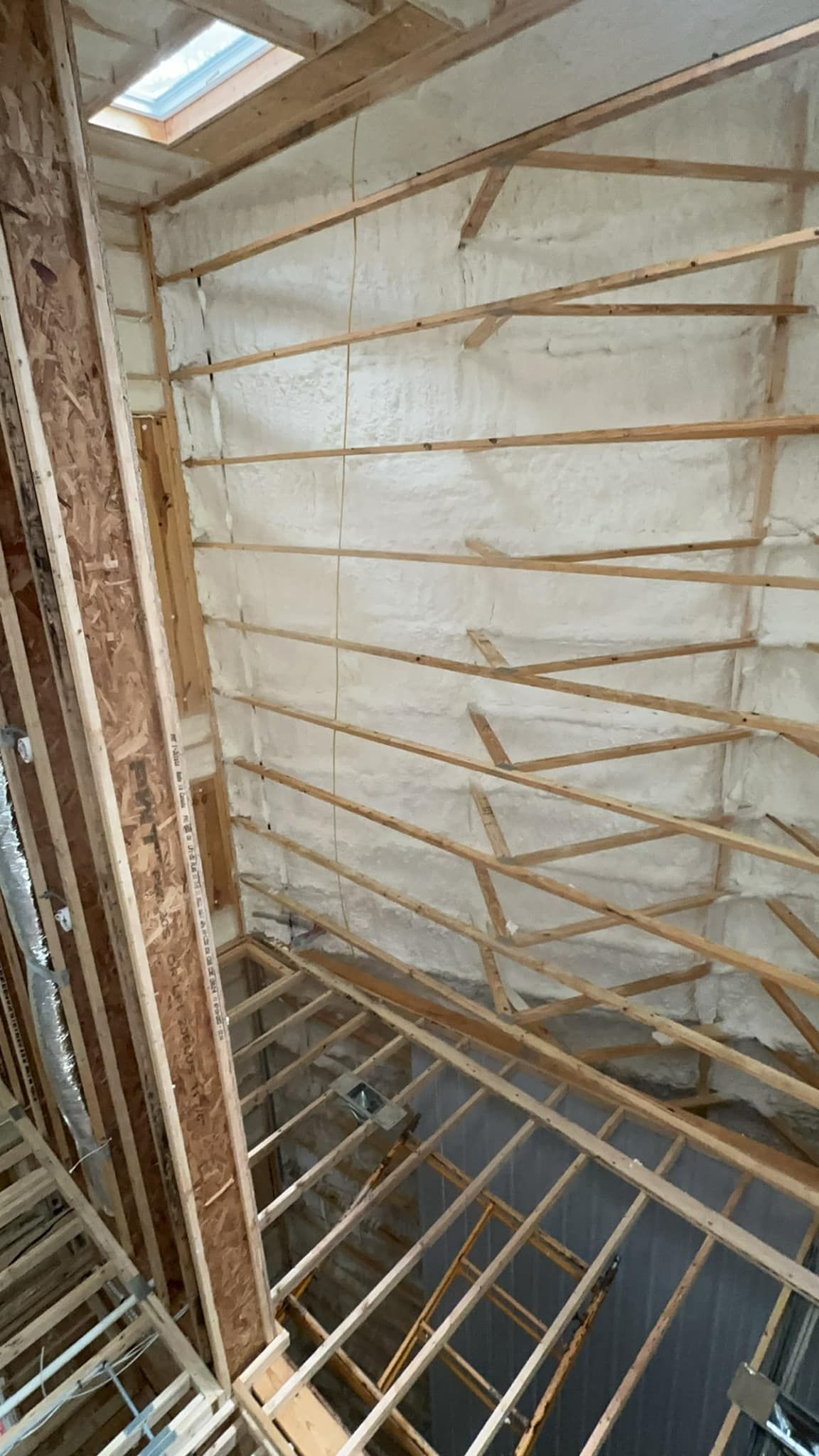 A room with a lot of wooden beams and a skylight in the ceiling.