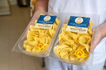 Pasta fresca, mattarello e tagliapasta su una superficie infarinata.
