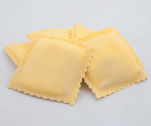Tre ravioli quadrati su sfondo chiaro