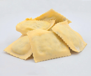 Diversi pezzi di pasta cruda per ravioli su sfondo bianco