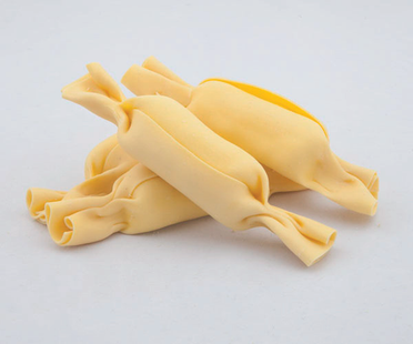 Mucchietto di strisce di pasta gialla cruda su sfondo bianco