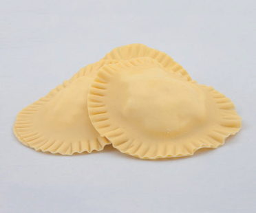 Tre pezzi di pasta cruda per ravioli su uno sfondo chiaro