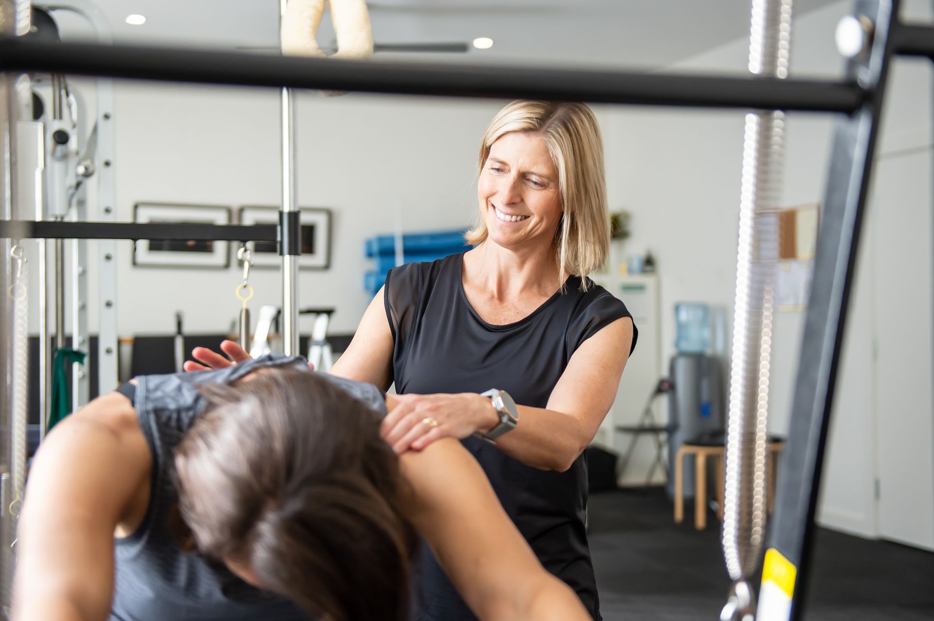 A woman is giving a woman a massage in a gym.