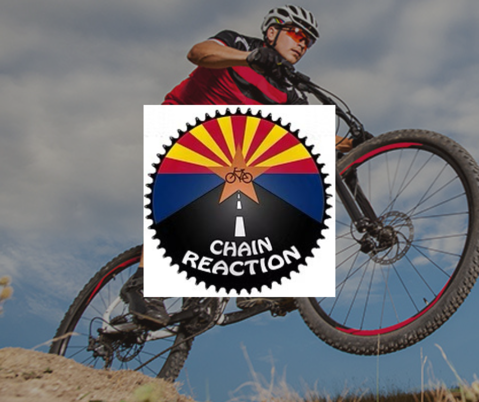 A man is riding a bike with a chain reaction logo behind him