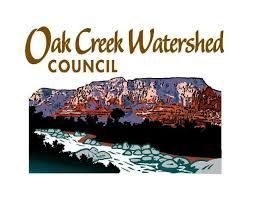 The logo for the oak creek watershed council shows a mountain and a river.