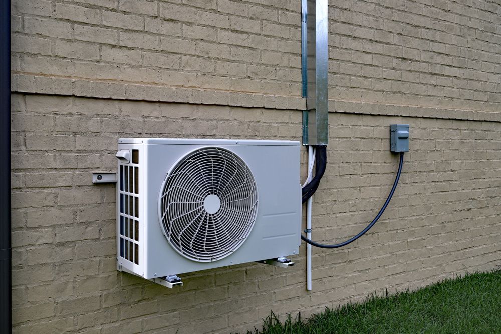 Heat pump installed on the exterior wall of a building.