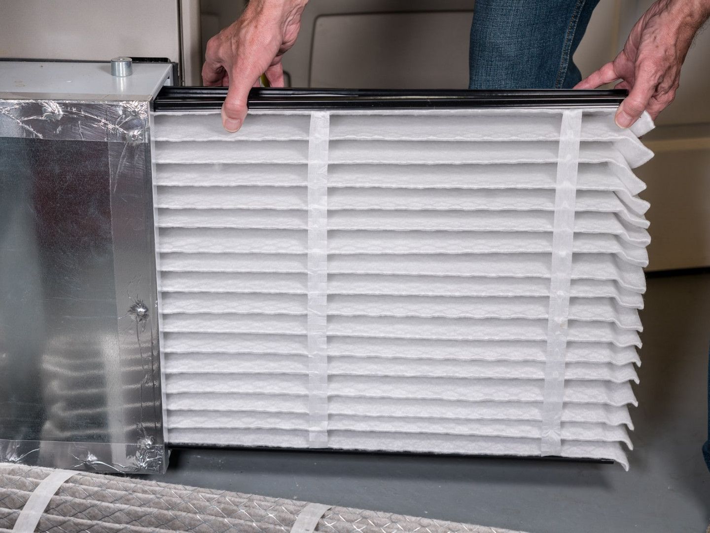 Professional HVAC technician replacing a furnace filter for optimal performance.