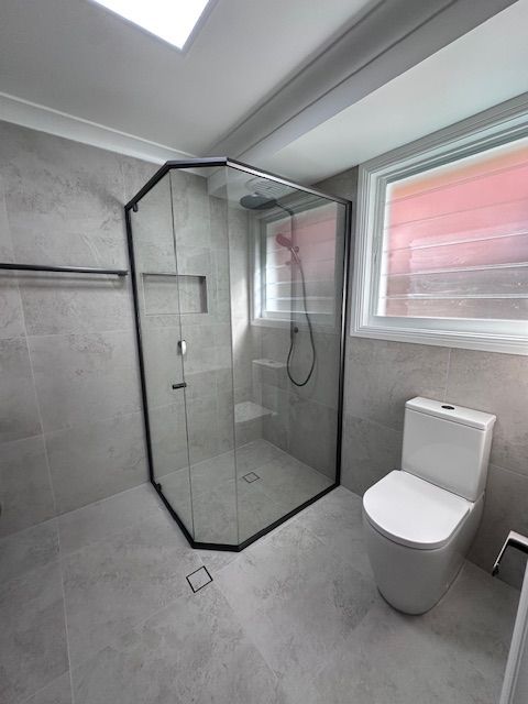 Modern Bathroom With Gray Tiles, a Black-framed Shower — Custom Design Bathroom Renovations in Port Macquarie, NSW