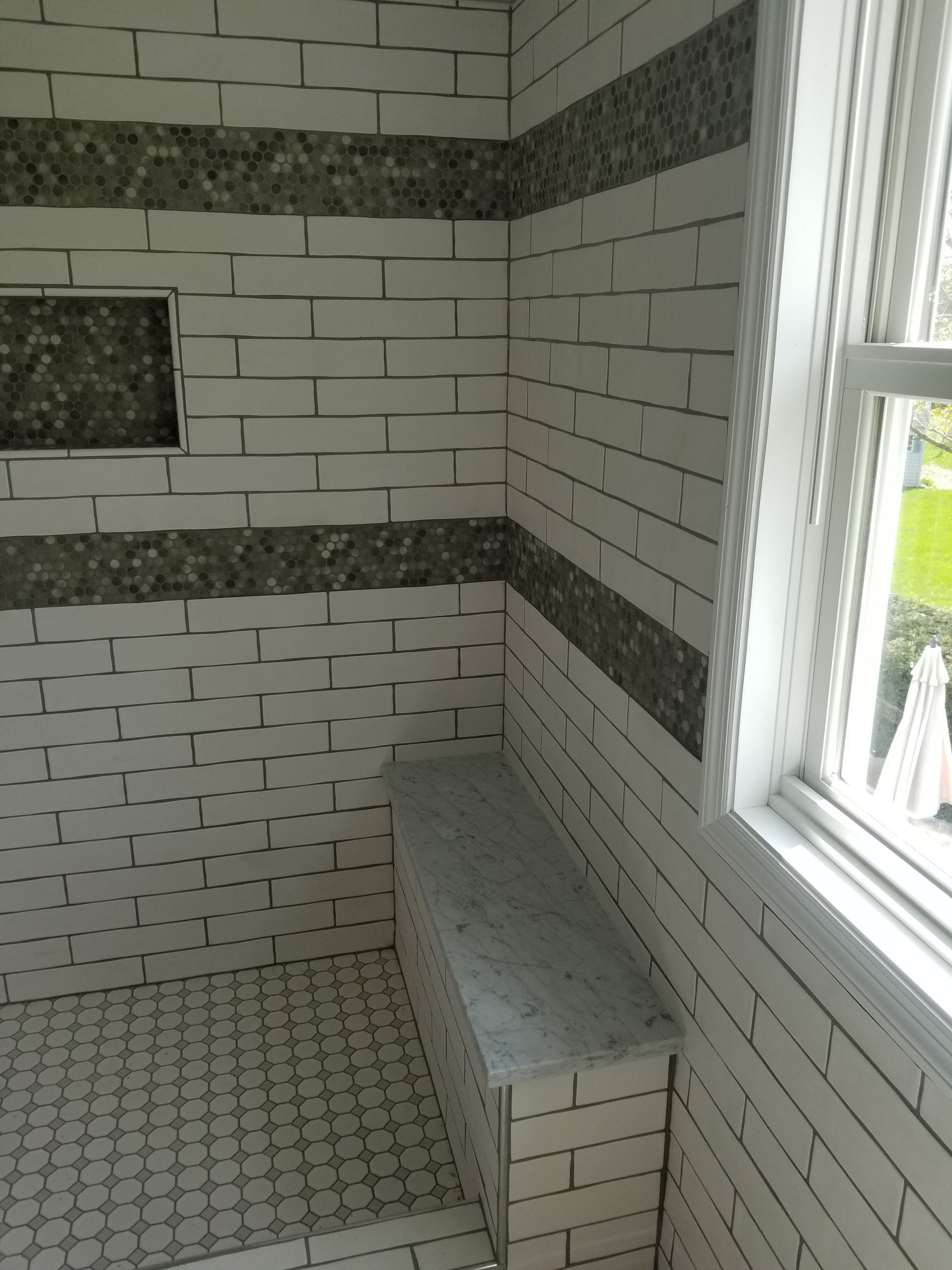 A bathroom with white brick walls and a window