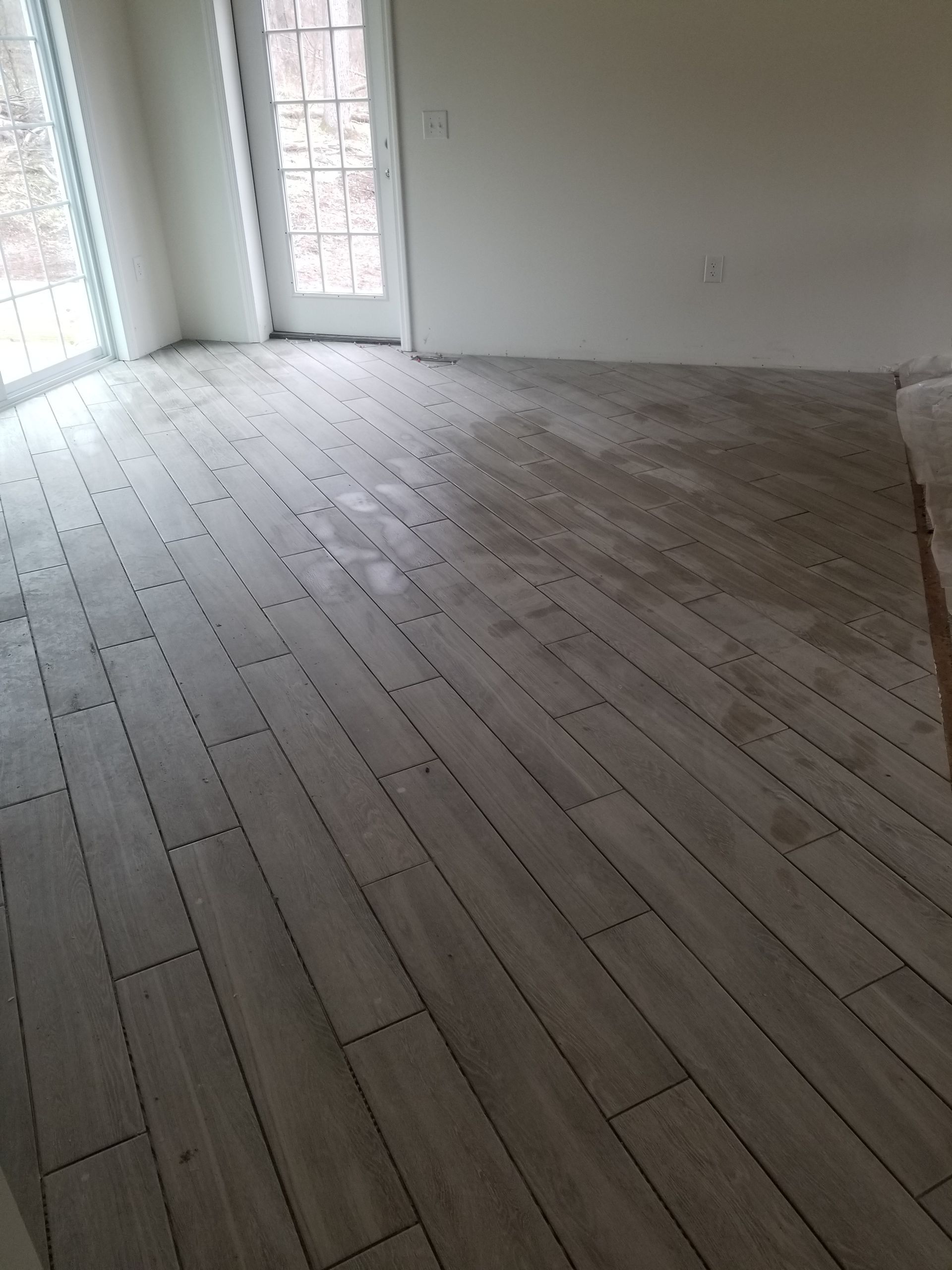 A room with a wooden floor and a sliding glass door.
