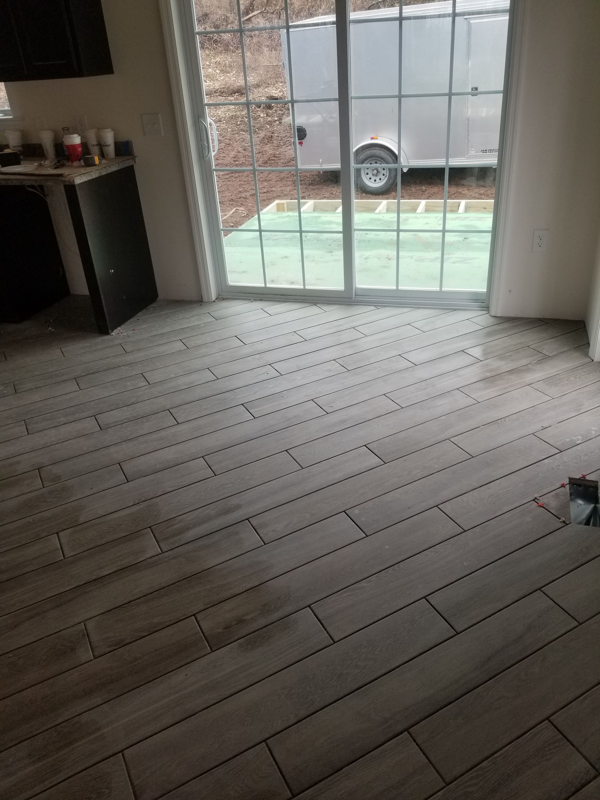 A room with a wooden floor and a sliding glass door.