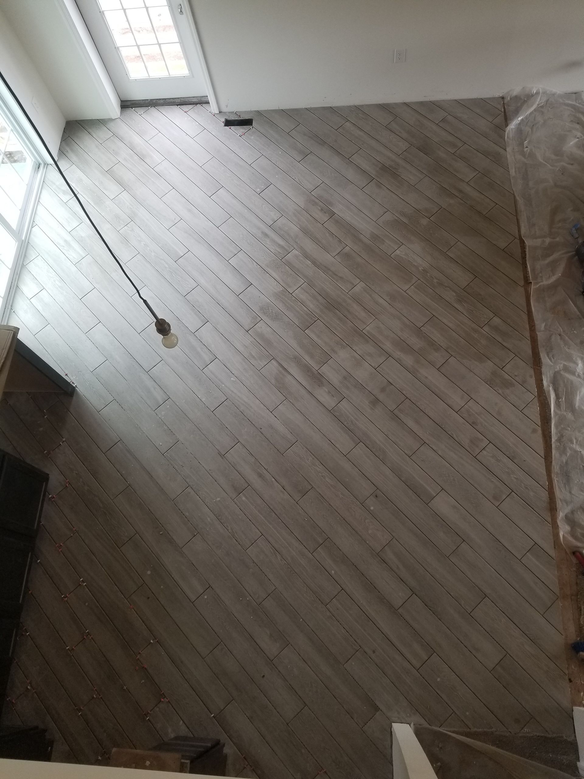 An aerial view of a room with a wooden floor and stairs.