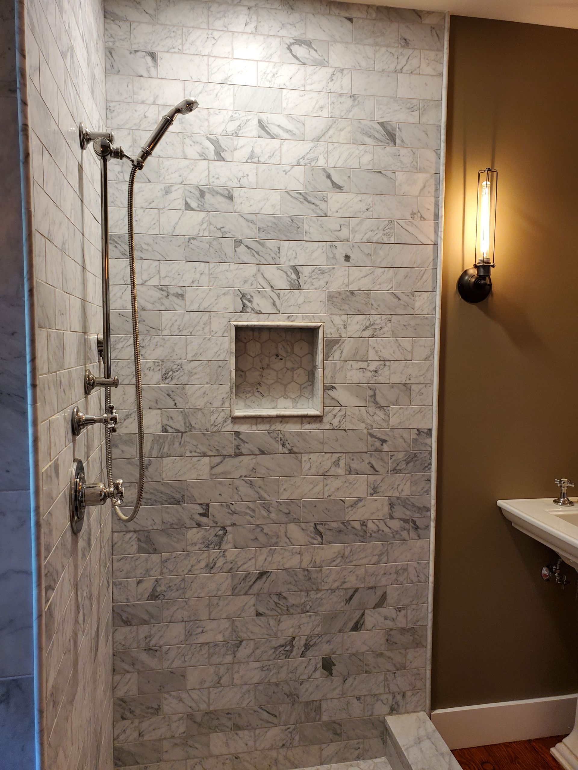 A bathroom with a walk in shower and a sink