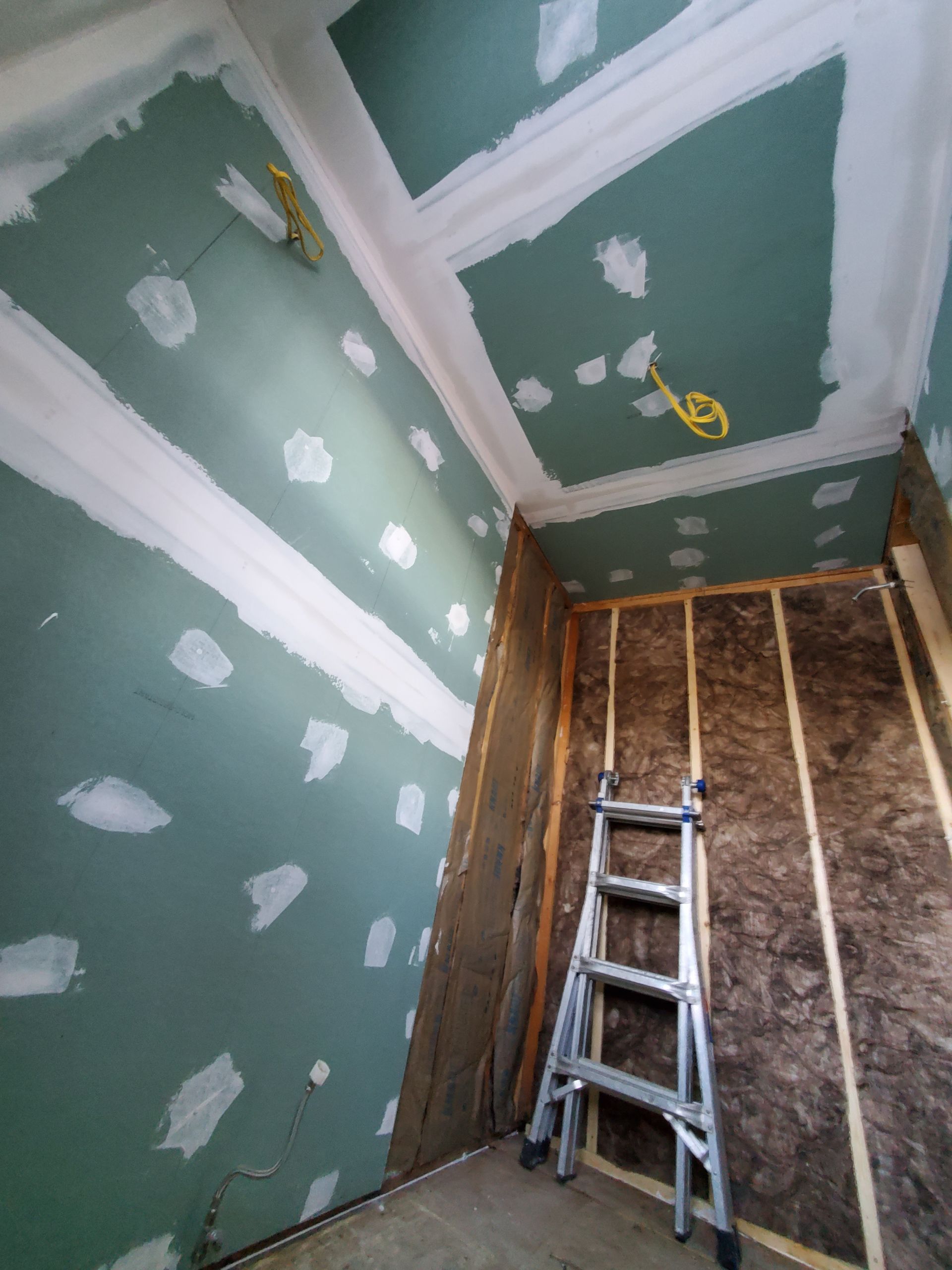 A ladder is sitting in a room that is being remodeled