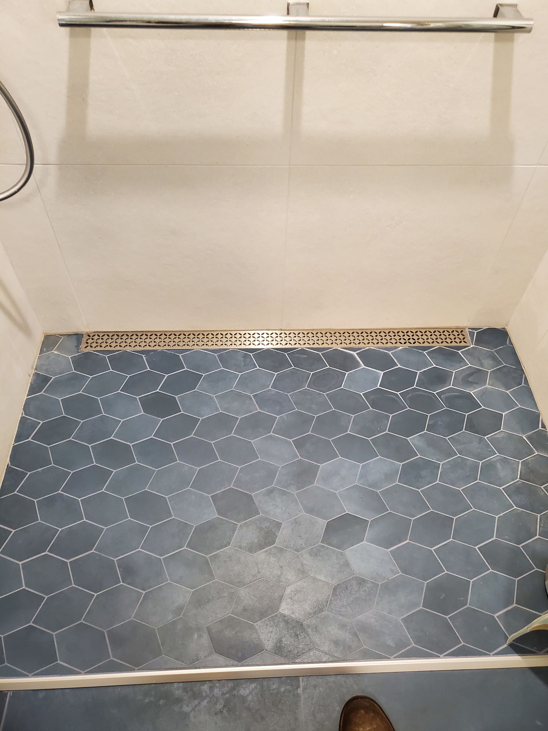 A person is standing on a tiled floor in a bathroom.