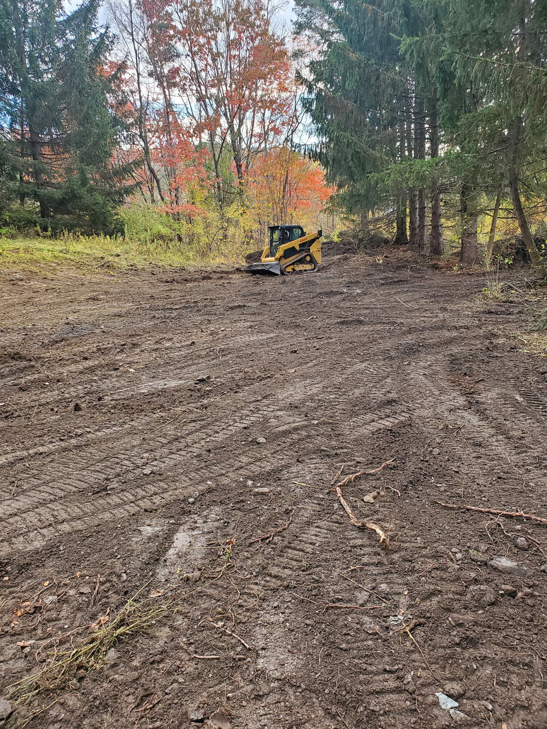 A bulldozer is sitting in the middle of a dirt field.