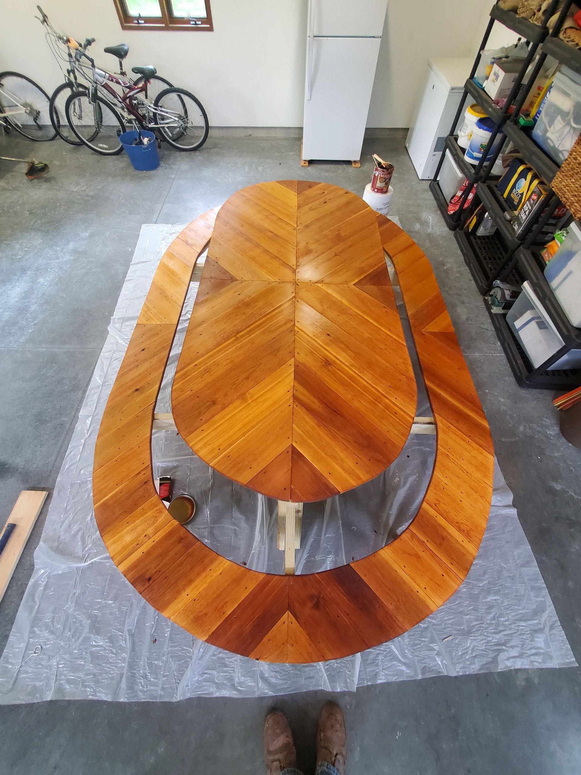 A wooden table in a garage with a bicycle in the background