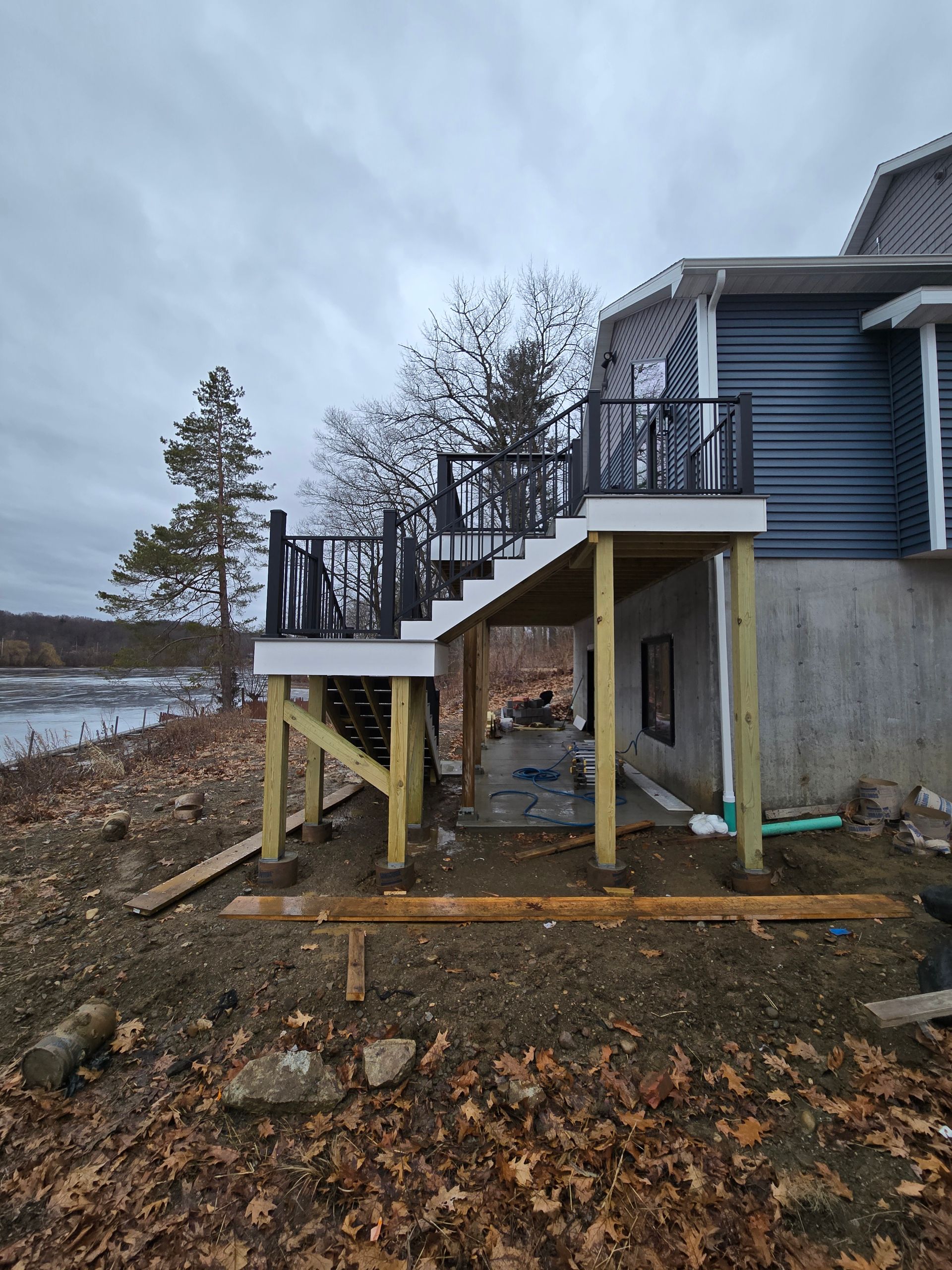 A house with a deck and stairs on the side of it.