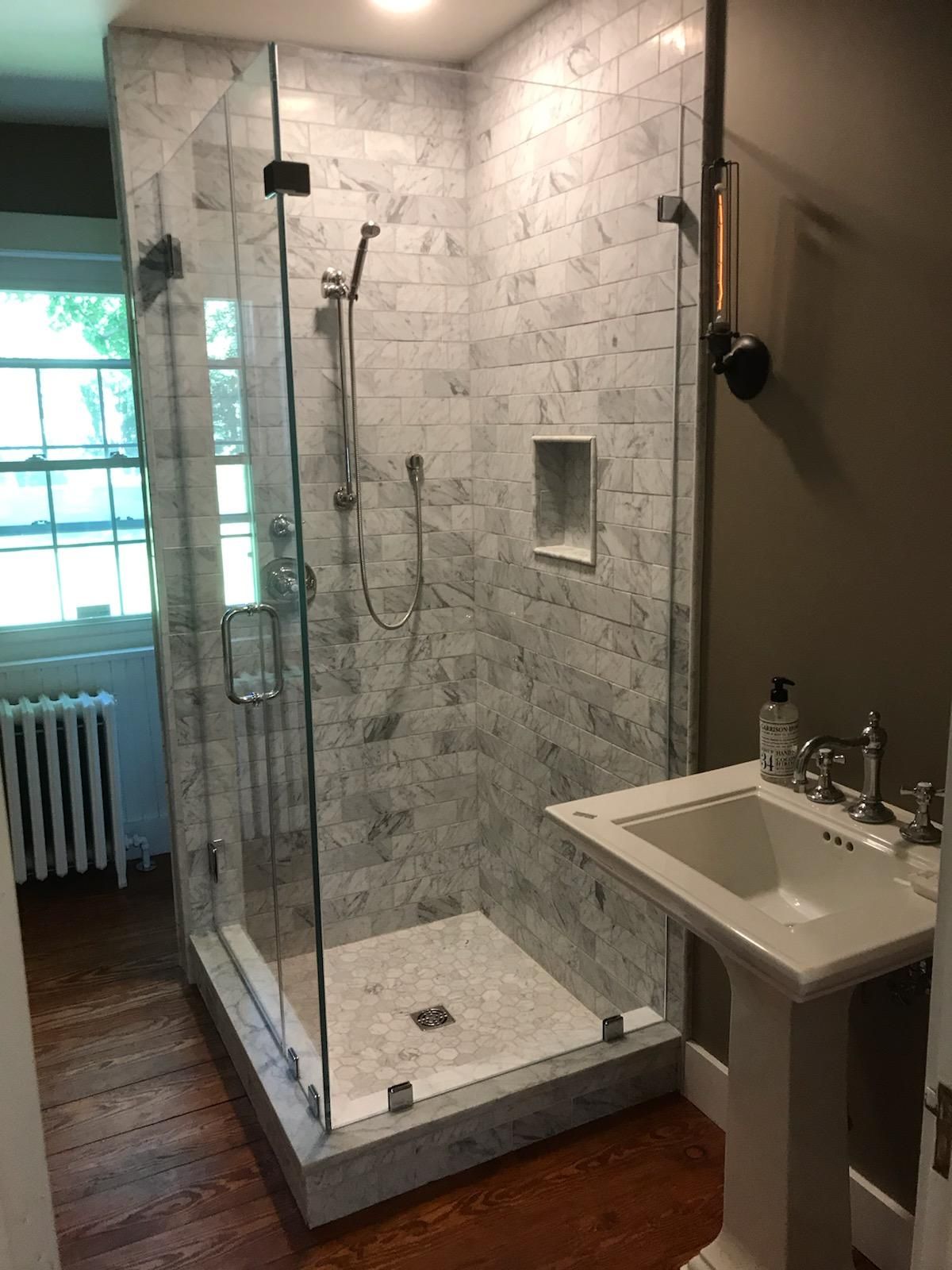 A bathroom with a walk in shower and a sink.