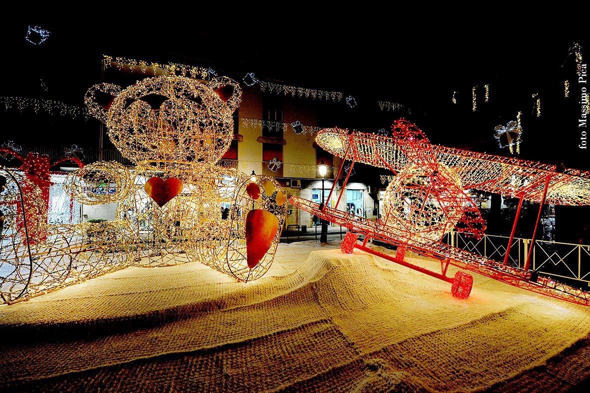 Una festosa esposizione all'aperto con una ruota panoramica illuminata e decorazioni rosse di notte